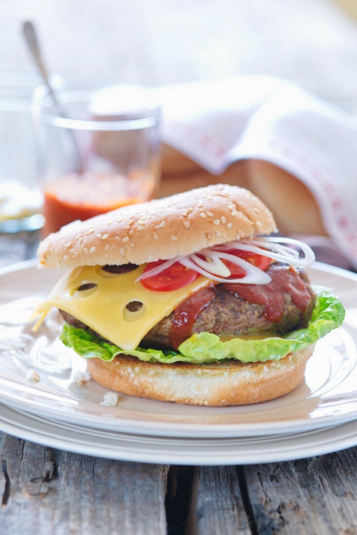 A hamburger with cheese, ketchup and onions
