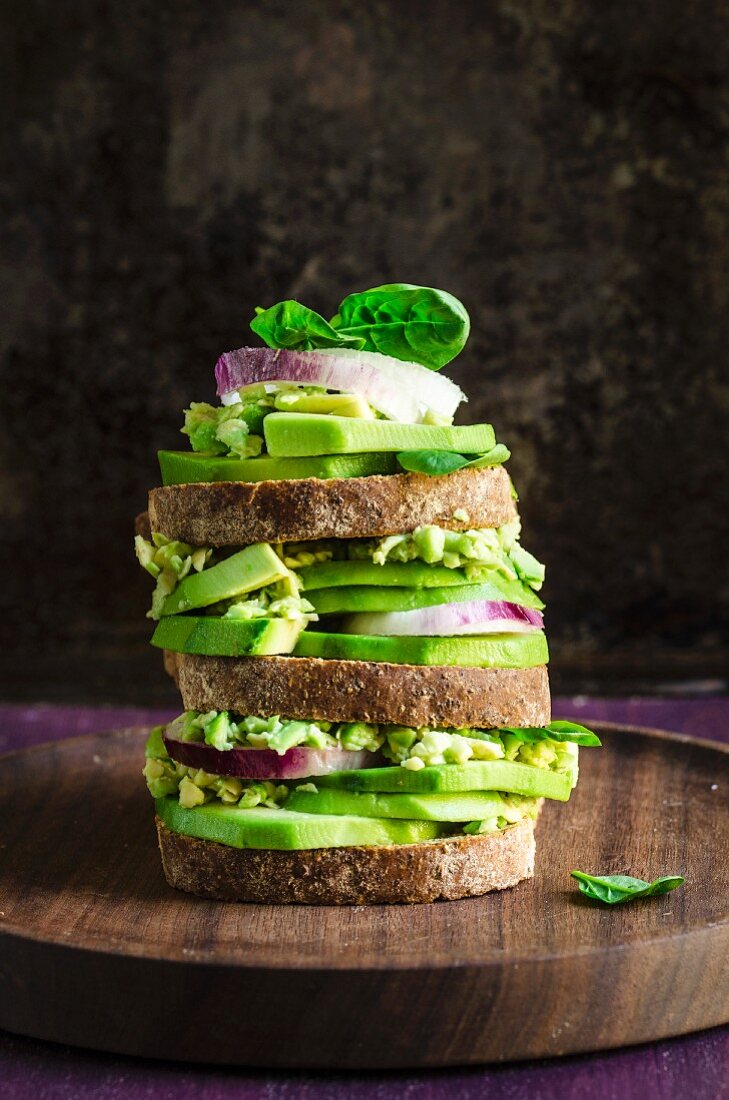 A stack of toasted avocado sandwiches