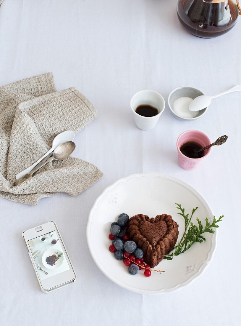 Mini-Bundt-Cake in Herzform mit geeisten Beeren zum Kaffee