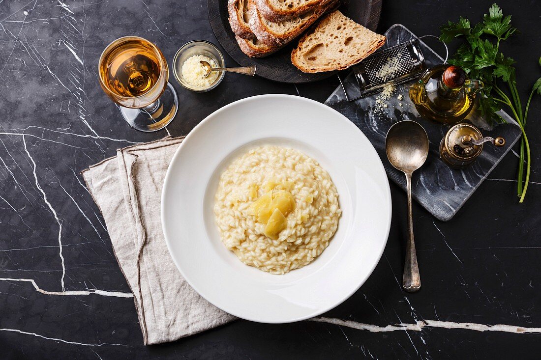 Risotto with parmesan cheese on plate on dark marble table background