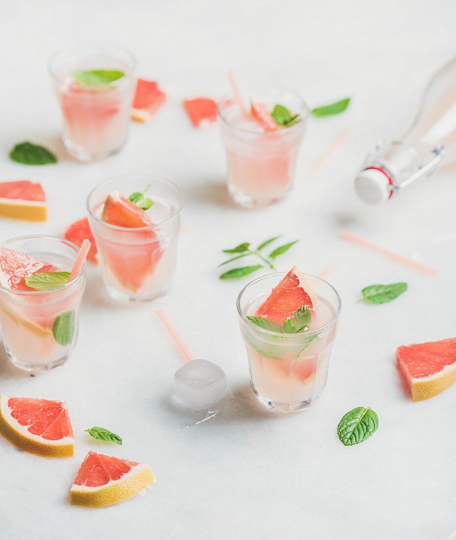 Erfrischender Sommercocktail mit Grapefruit, Minze und Eis in Gläsern