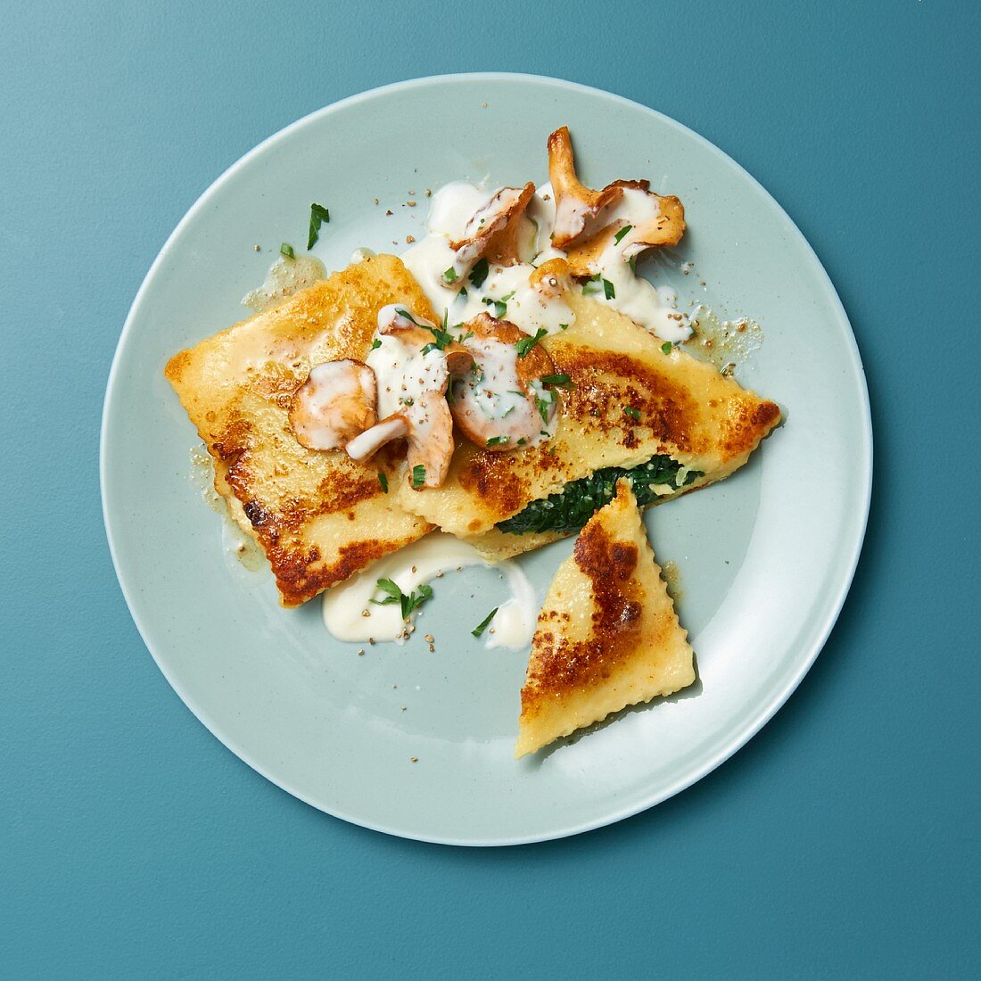 Fried potato dumplings with gorgonzola and spinach and cream, on chanterelles