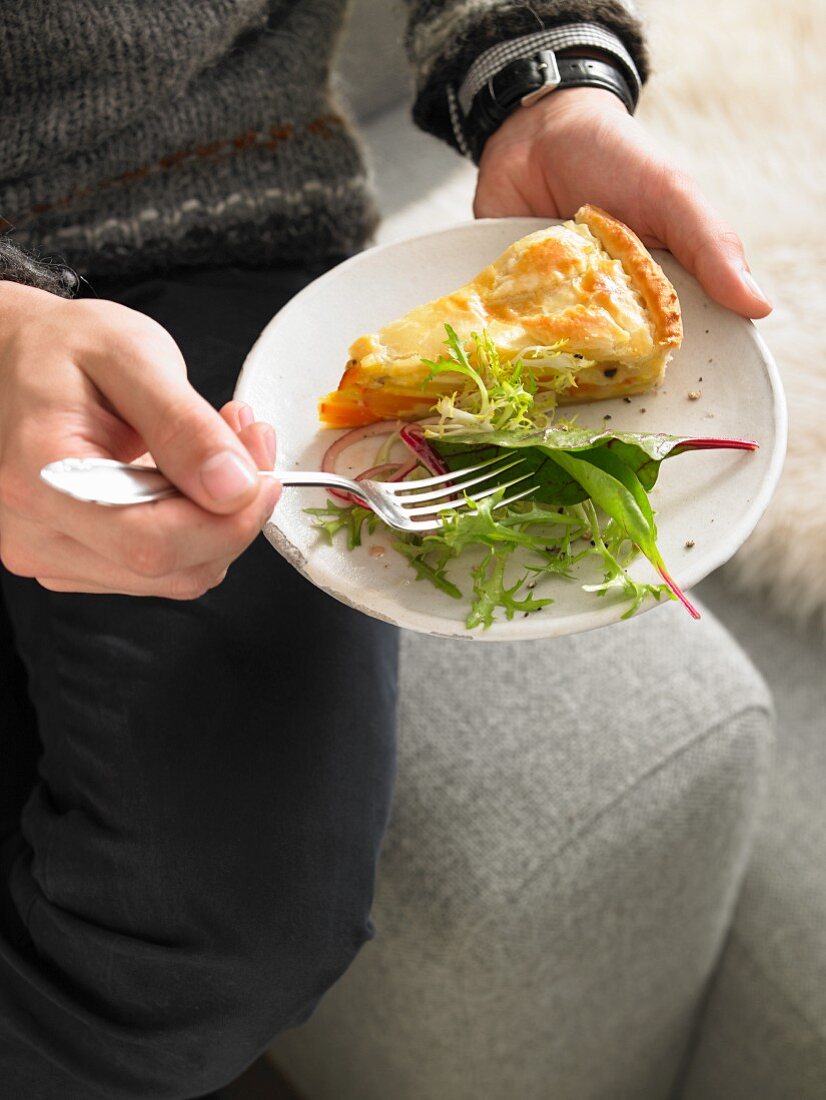 Ein Stück Kürbis-Kartoffel-Pastete mit Blattsalat