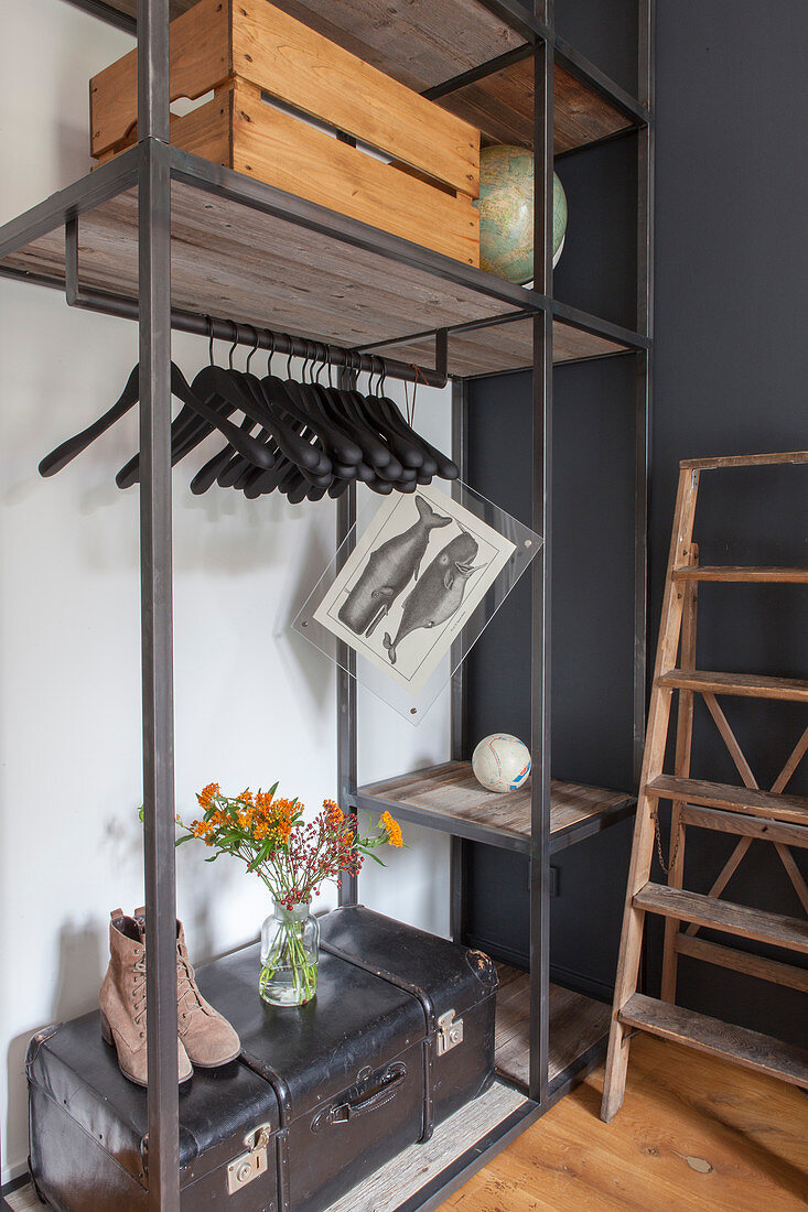 Old trunk and wooden crate on industrial-style clothes rack