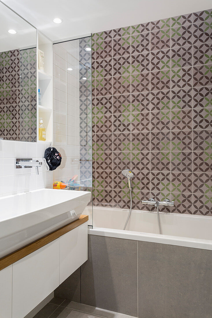 Patterned tiles above bathtub in small bathroom