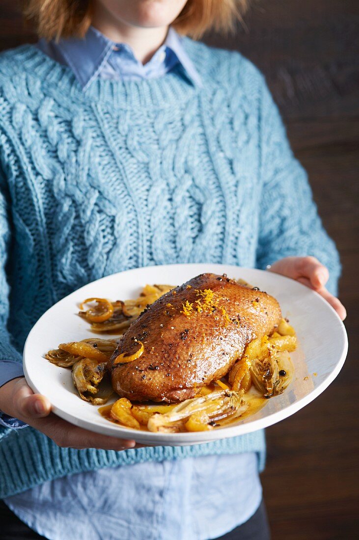 A woman holding a plate of fried goose breast