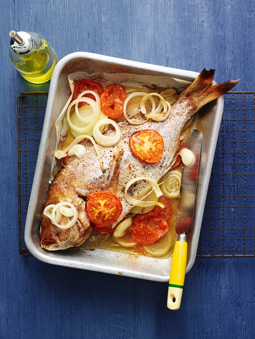 Snapper with onion and tomatoes from the oven