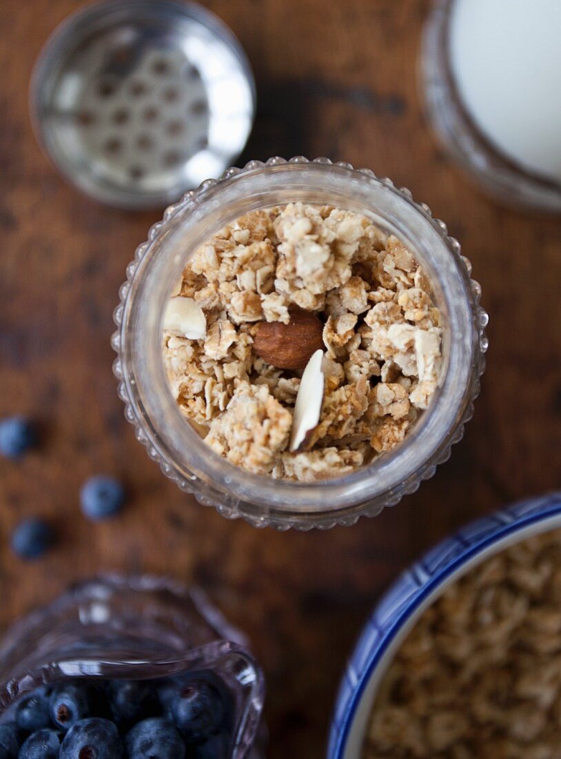 Granola in an antique jar, wild blueberries in a glass jar and granola in a bowl