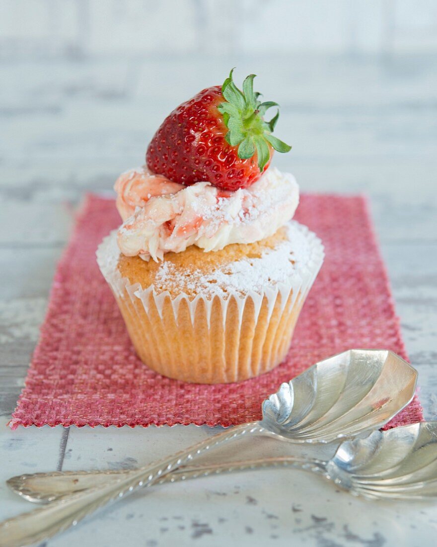 Cupcakes with strawberry cream and topped with a fresh strawberry