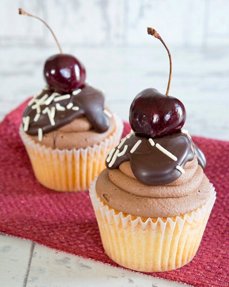 Cupcakes with chocolate icing and a cherry