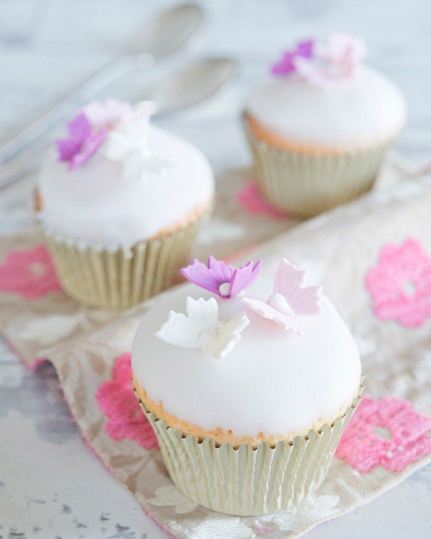 Cupcakes with a fondant glaze and sugar butterflies