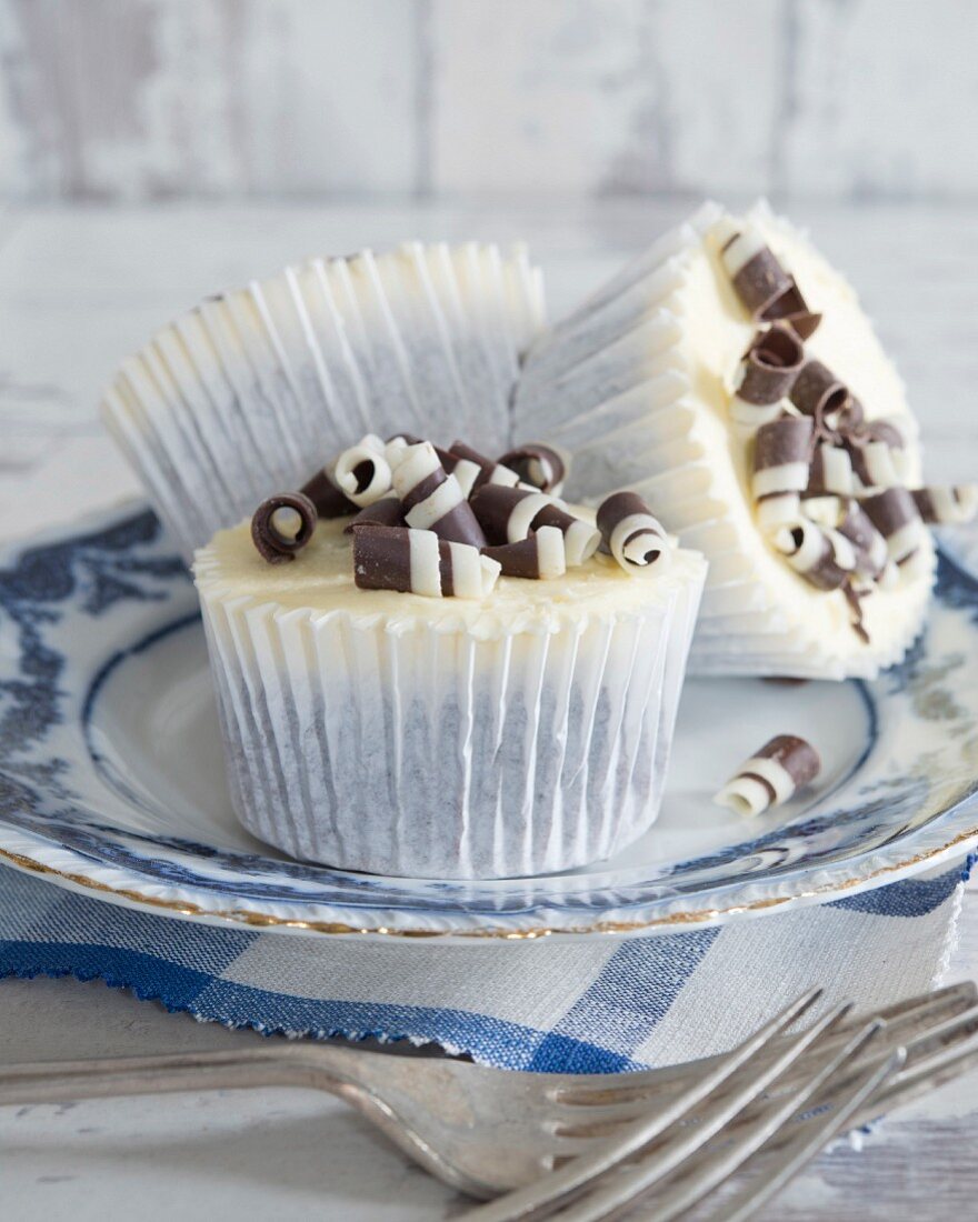 Cupcakes mit Buttercreme und schwarzweissen Schokoröllchen