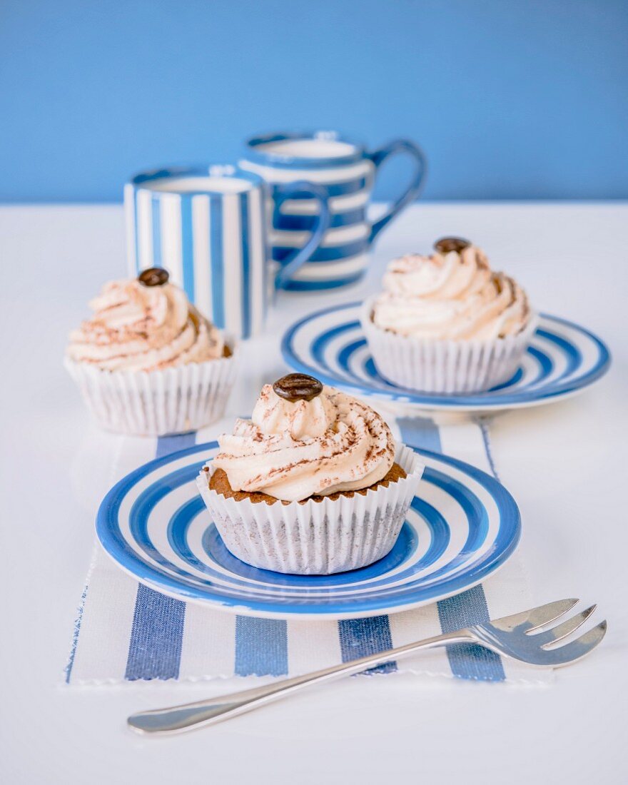 Cupcakes with buttercream, cocoa powder and a mocha bean on the top