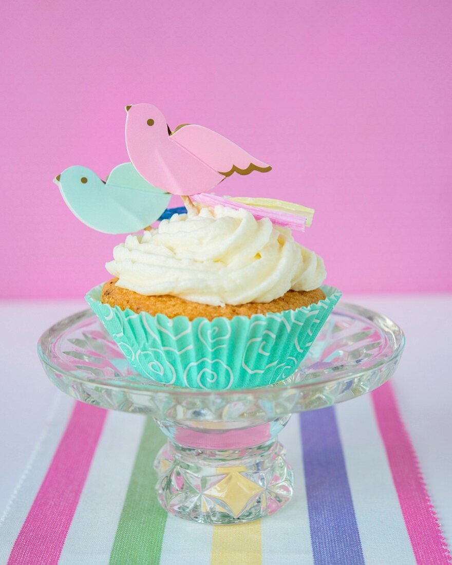 Cupcake mit Buttercreme und Papiervögeln