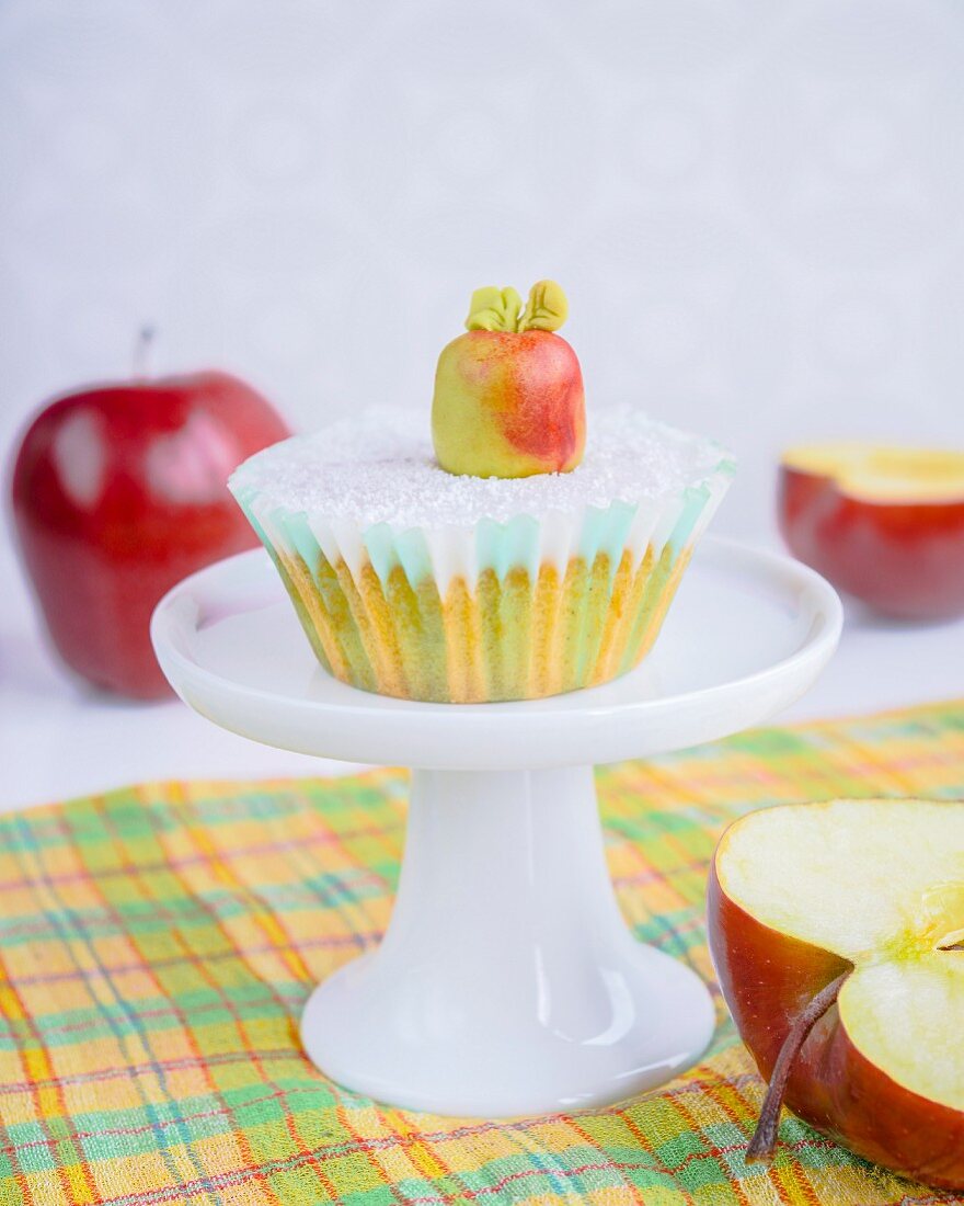 A cupcake with fondant icing and a marzipan apple