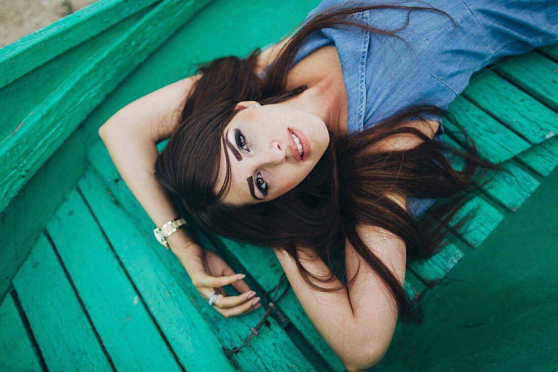 Woman lying on green boardwalk