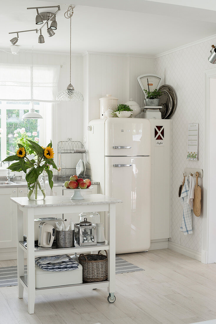 Vase of sunflowers on serving trolley in country-house kitchen