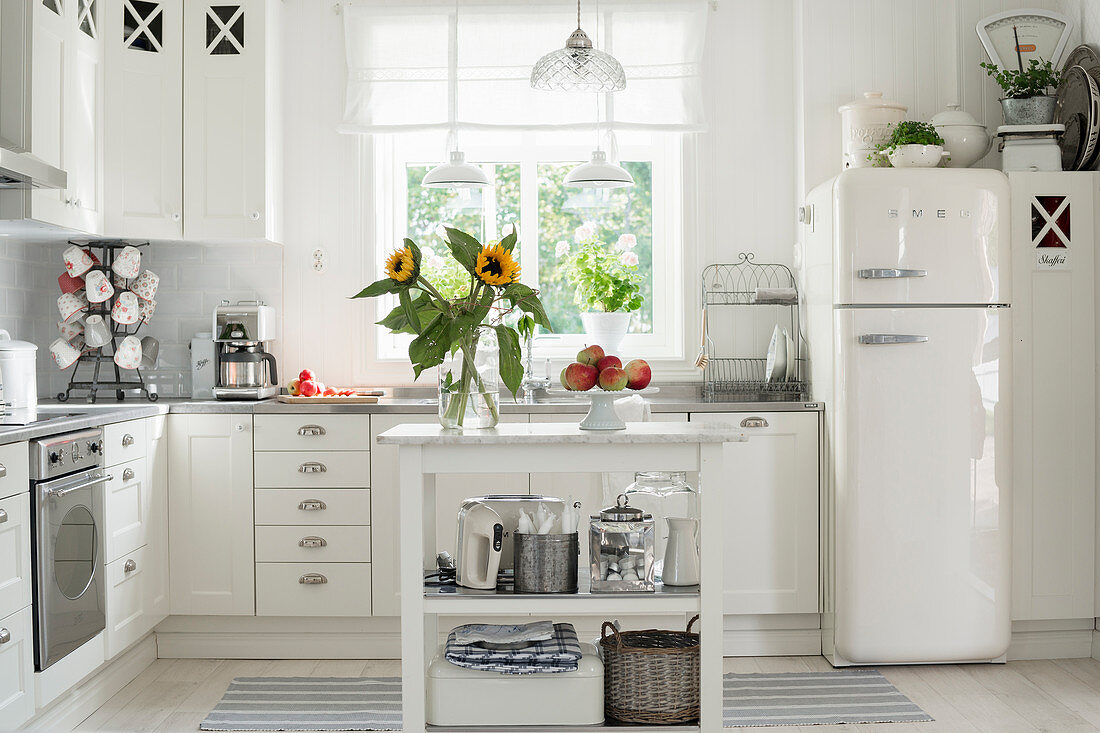 Vase of sunflowers on serving trolley in country-house kitchen