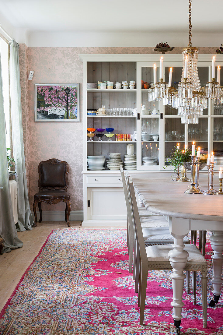 Oval table and glass-fronted cabinet in classic dining room