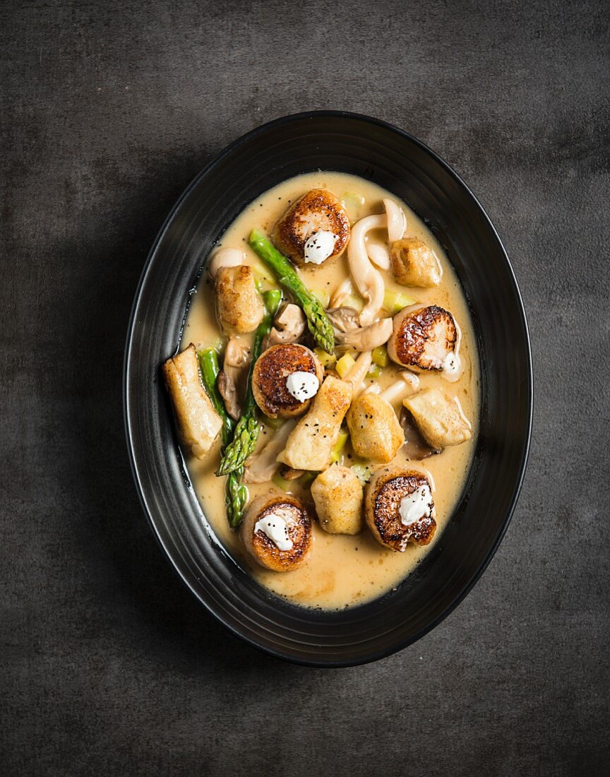 Fried mussels in mushroom sauce with asparagus tips