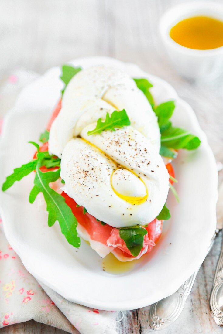 Büffelmozzarella, gefüllt mit Parmaschinken, Tomaten und Rucola