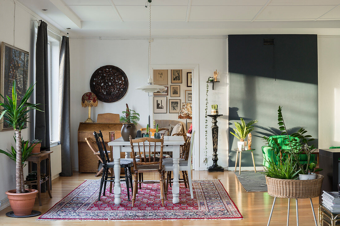 Verschiedene Stühle um den Tisch auf einem Teppich im Wohnzimmer