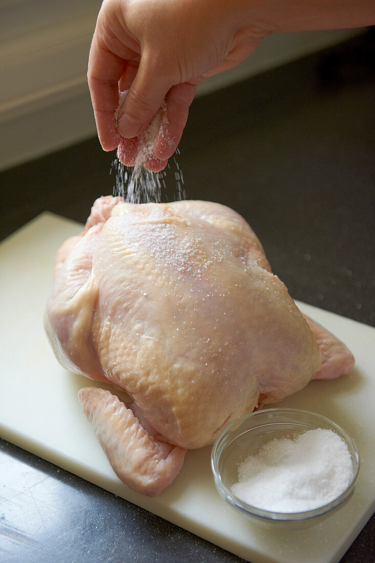 Frisches Huhn mit Salz bestreuen