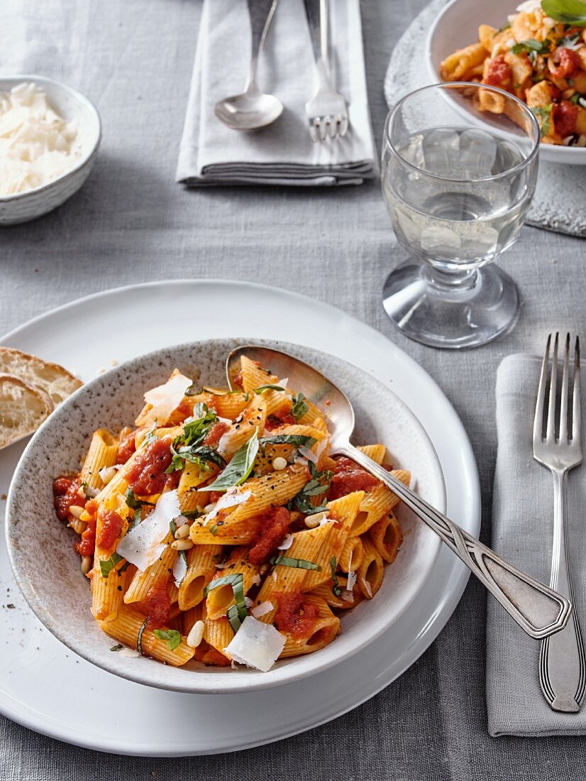 Penne mit Tomatensauce, Basilikum, Pinienkernen und Parmesan