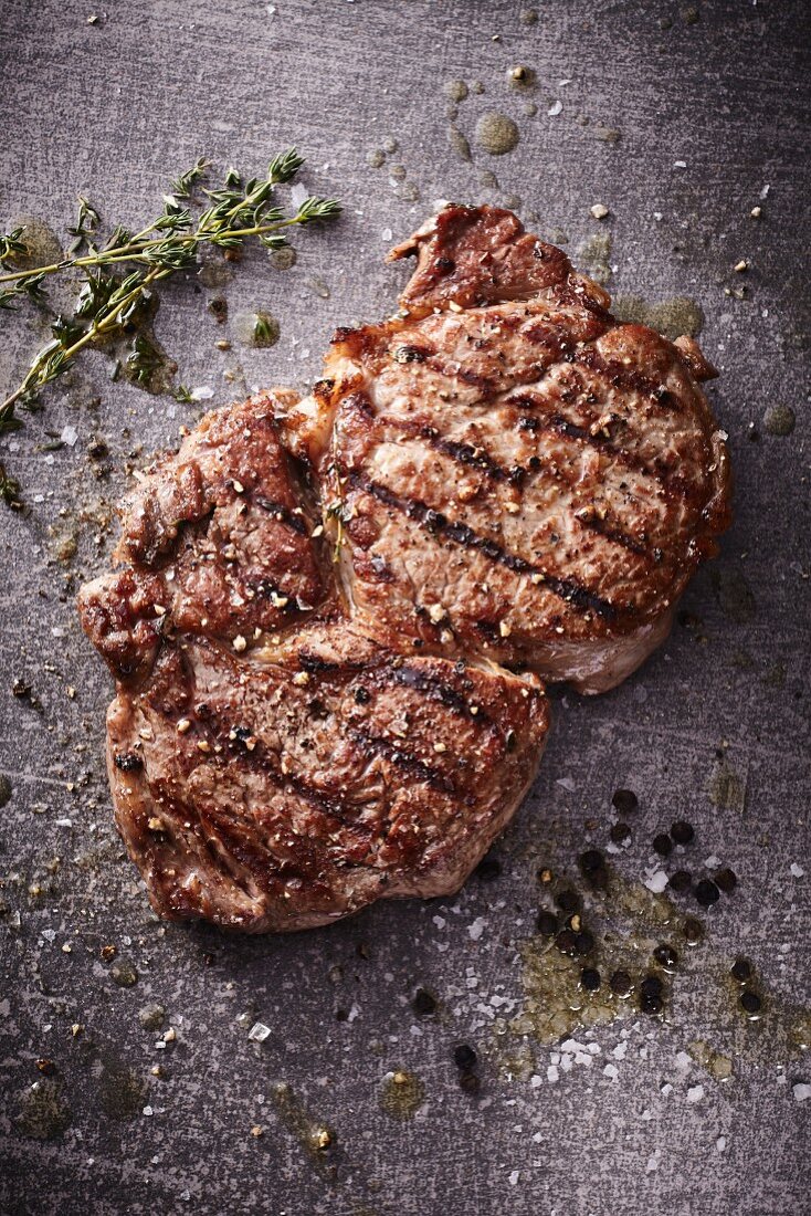 A grilled rib-eye steak with thyme, salt and pepper