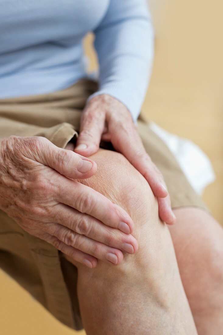 Senior woman holding sore knee
