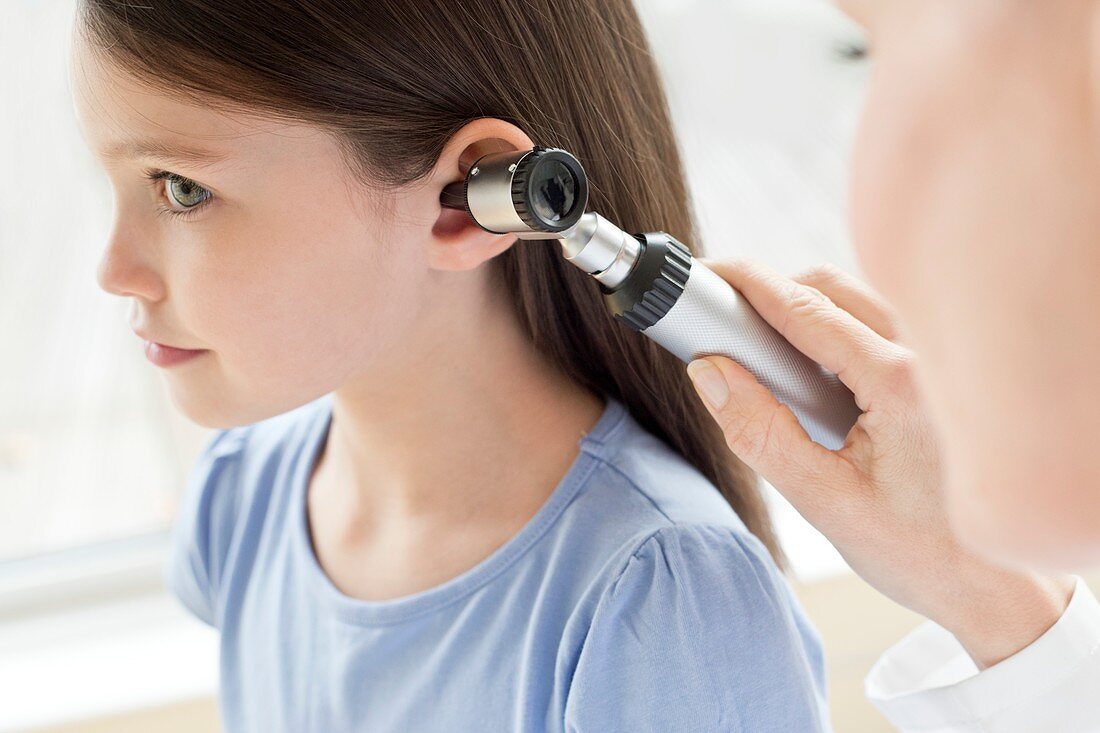 Female doctor examining girl's ear