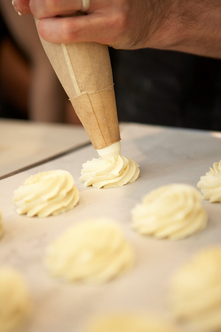 Piping pastry, piping raw dough onto baking tray with piping bag
