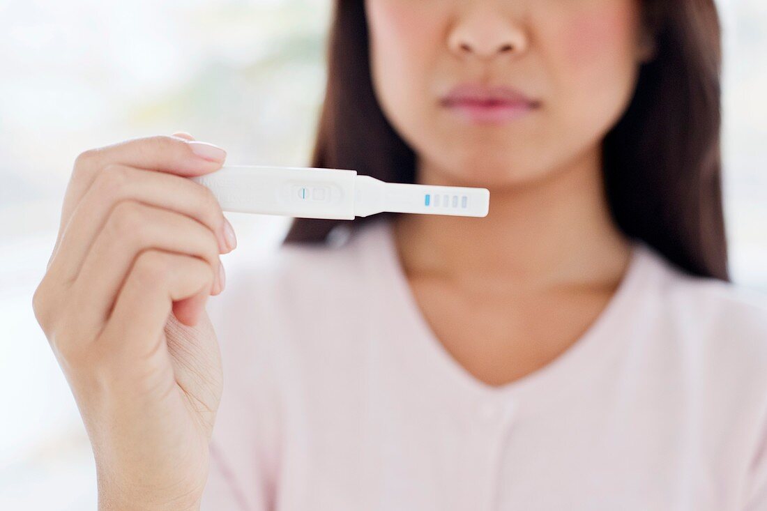 Woman holding pregnancy test