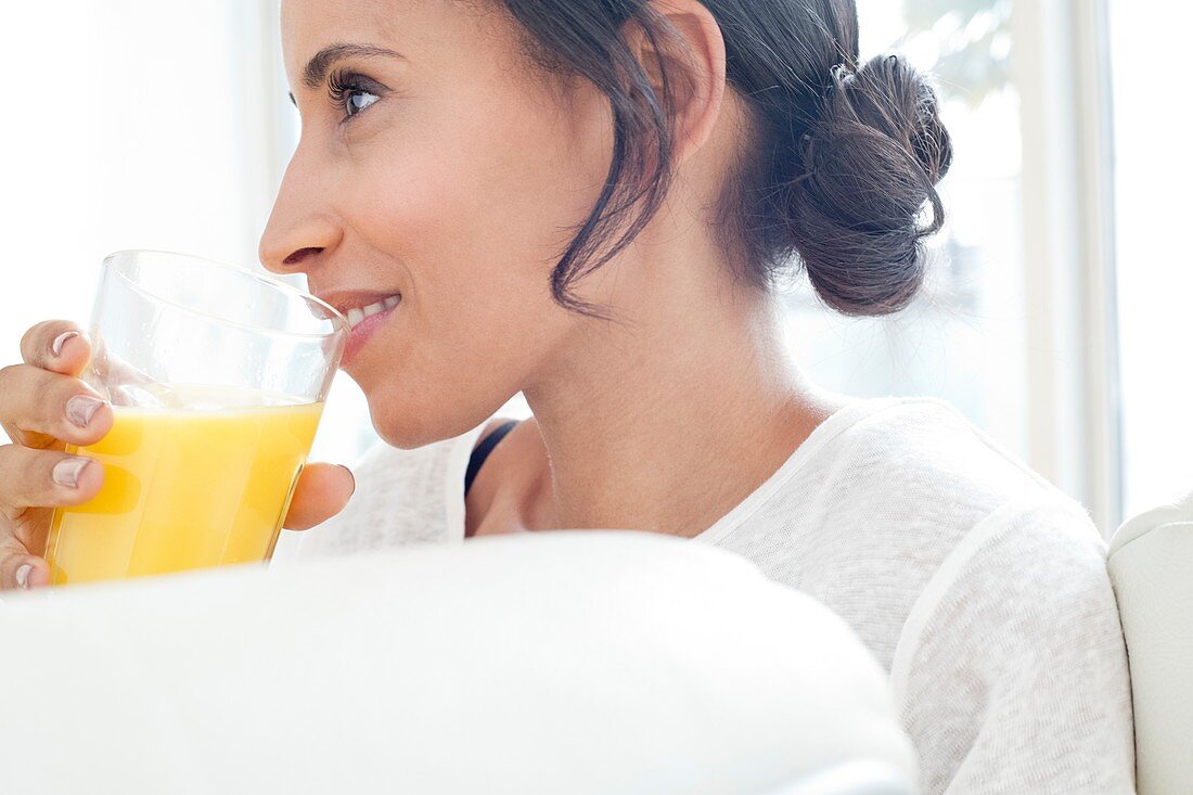 Woman drinking glass of orange juice