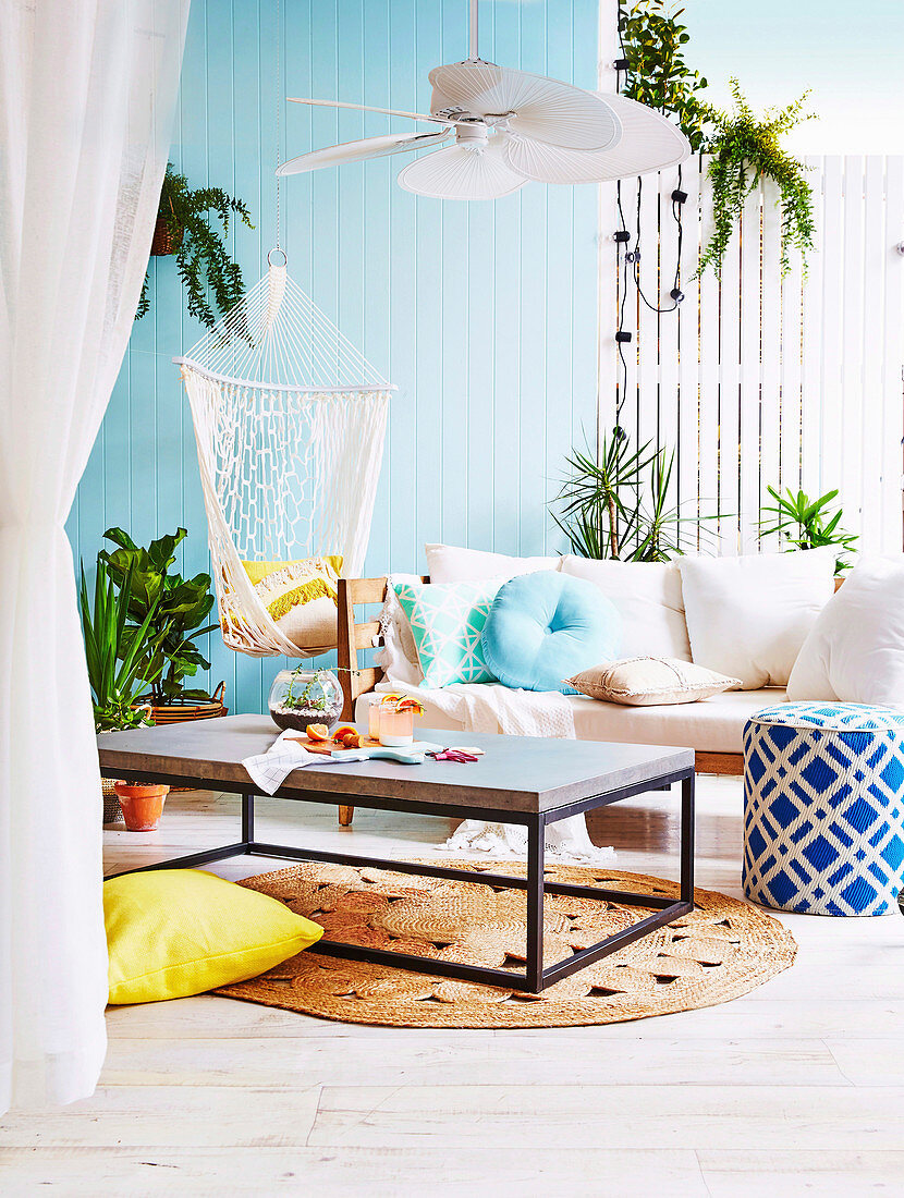 Somer feeling on the terrace with a blue wooden wall and sofa