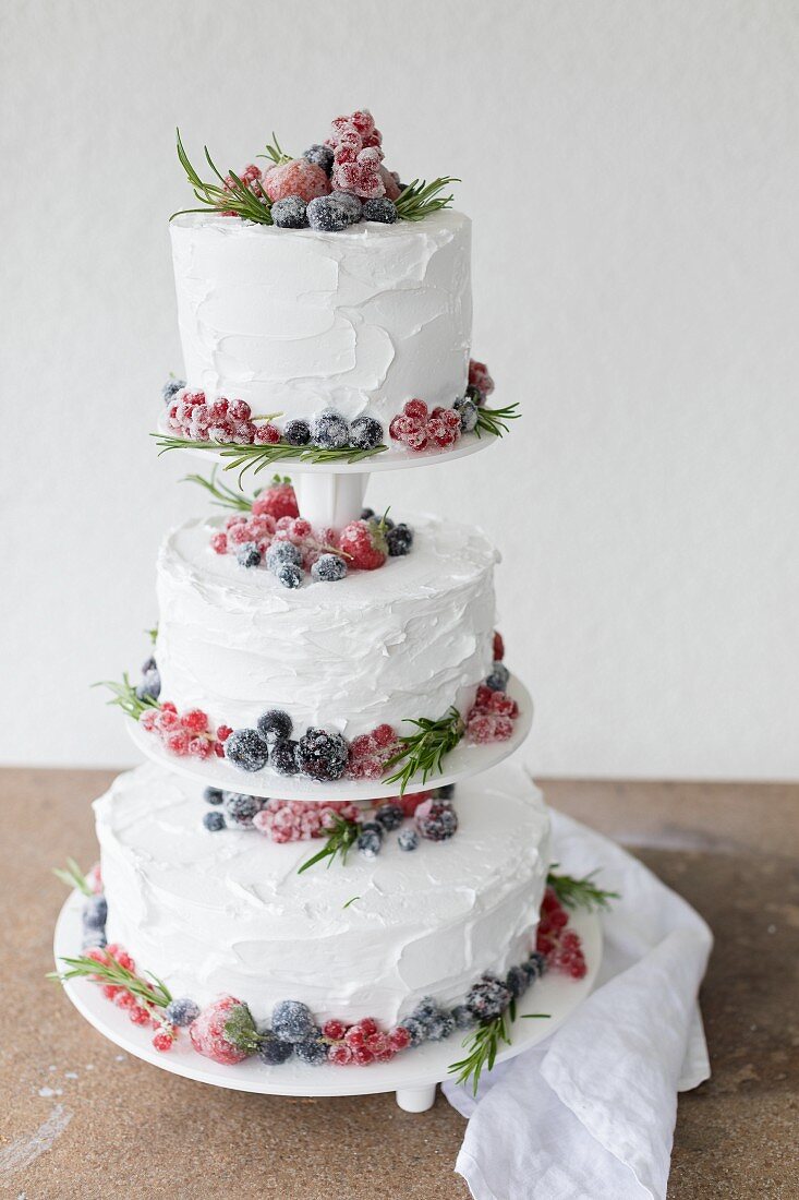 A three-tiered wedding cake with sugar-coated berries