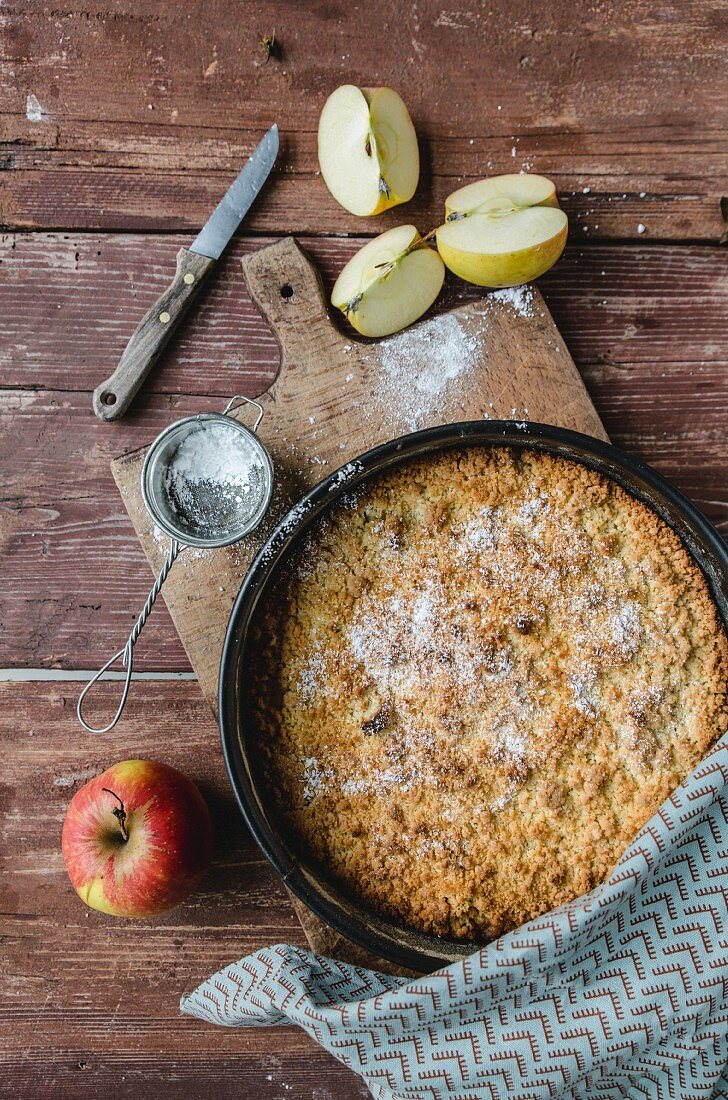 Apfelkuchen, frische Äpfel und Puderzucker