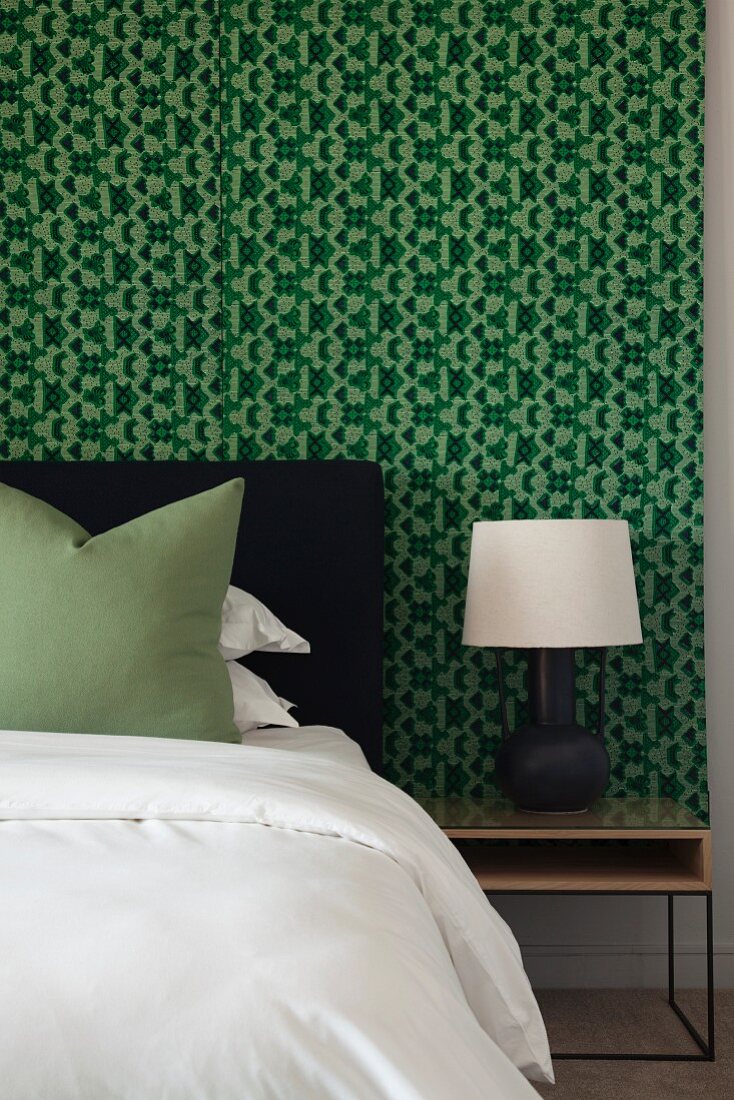 Schlafzimmer in Schwarz, Weiß und Grün mit grafisch gemusterter Wand