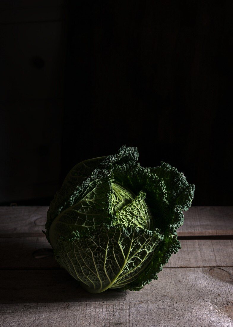 A savoy cabbage on a wooden surface