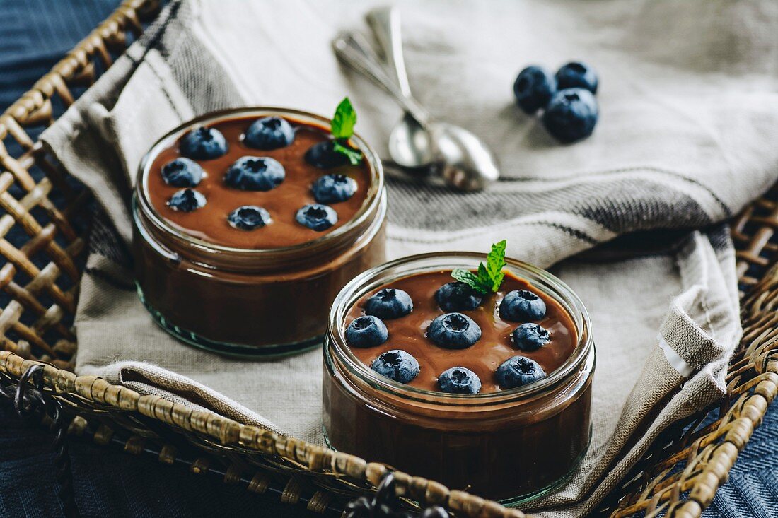 Chocolate pudding with blueberries in glass jars