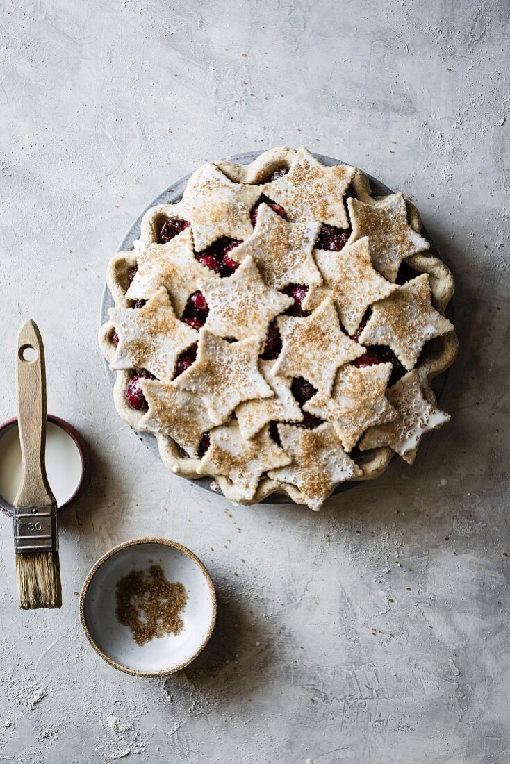 Unbaked cherry pie with shortcrust pastry stars and cinnamon sugar