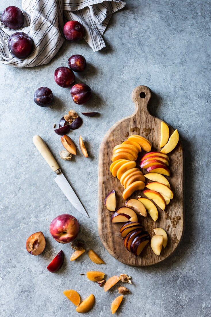 Peach, nectarine and plum wedges on a wooden chopping board