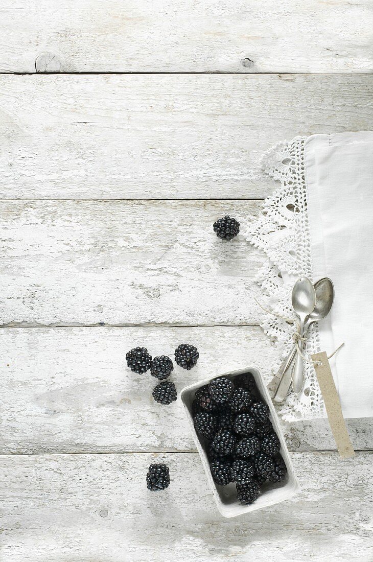 Blackberries in a white tub on a wooden table