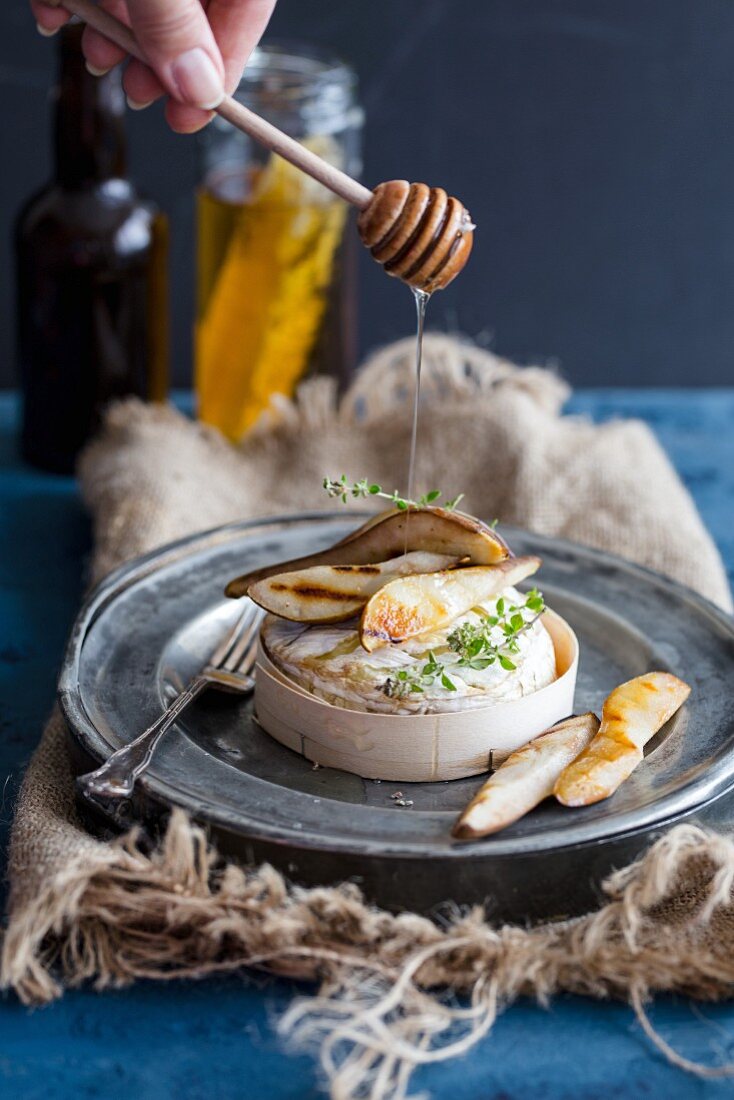 Gebackenen Camembert und glasierte Birne mit Honig beträufeln