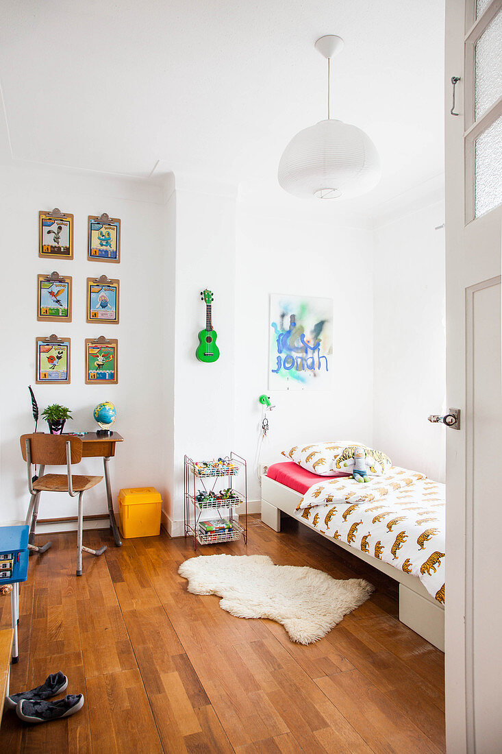 Blick ins Kinderzimmer mit Bett und kleinem Schreibtisch