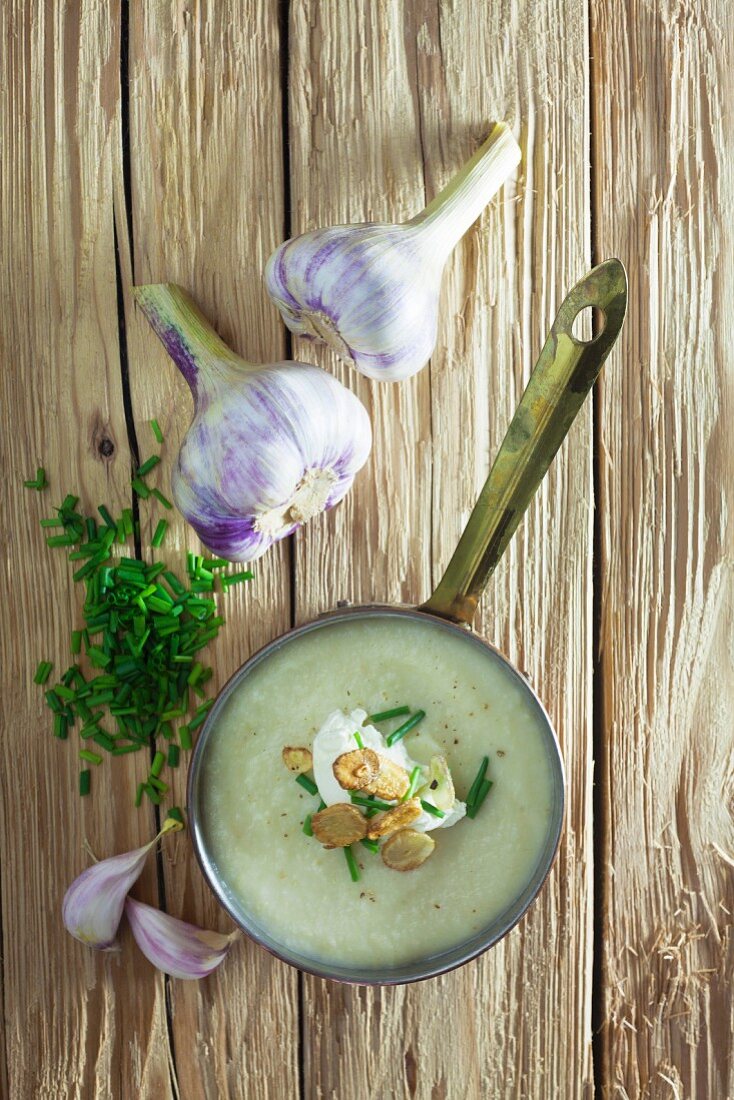 Garlic soup in a saucepan on a wooden background