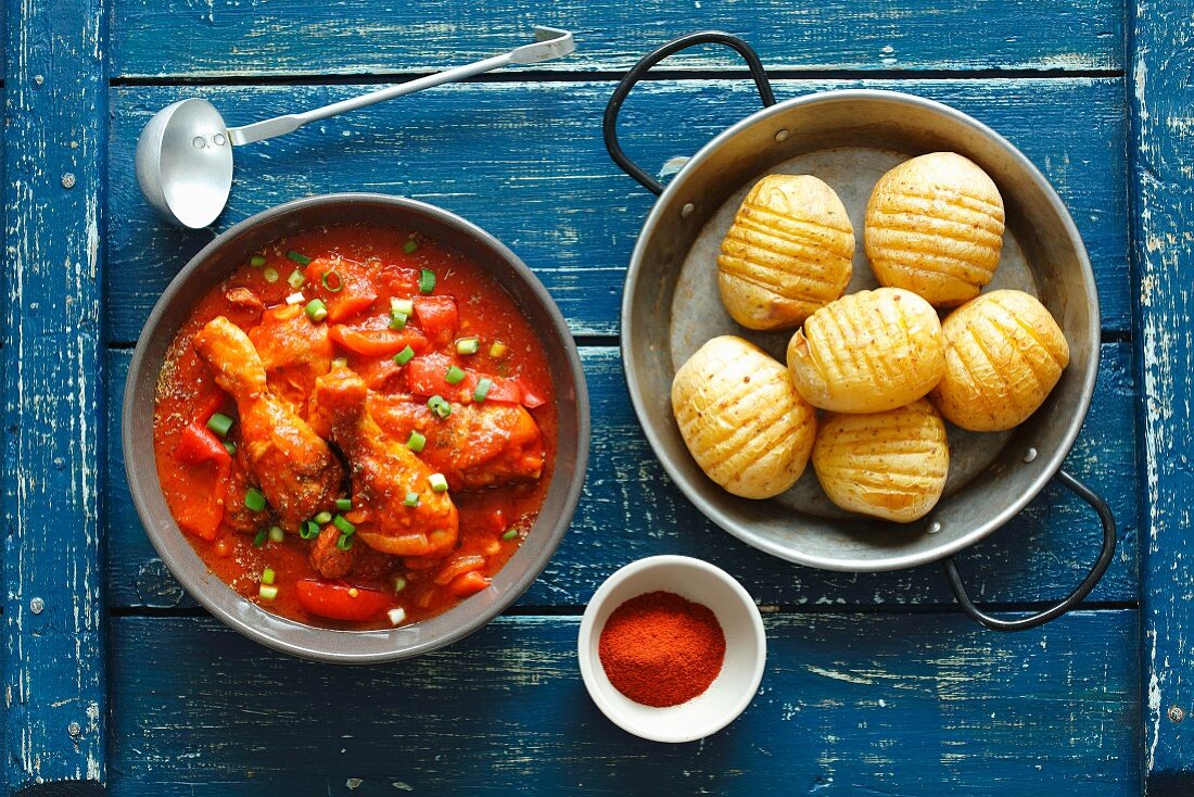 Chicken drumsticks with chorizo in tomato sauce and baked potatoes
