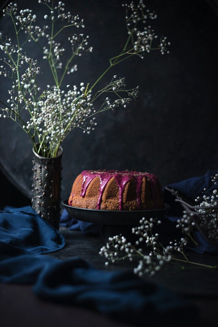 A vegan ring-shaped Bundt cake with raspberry and hibiscus frosting