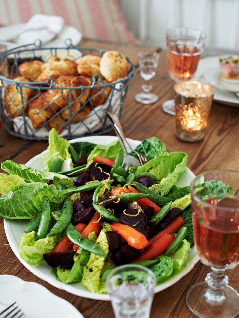 Romaine lettuce with carrots, beetroot, sugar snap peas and croissants