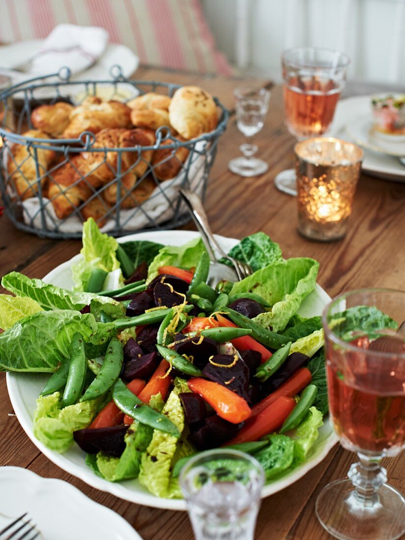 Romanasalat mit Möhren, Rote Bete, Zuckerschoten und Croissants